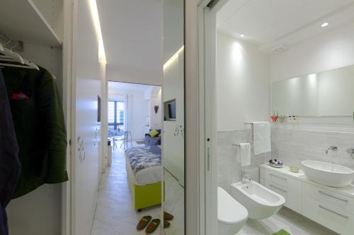 a white bathroom with two sinks and a mirror at Boutique House Fiò in Ischia