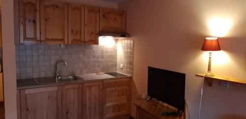 a kitchen with a sink and a television and a lamp at Residenze Sonnenschein Casa Rossa in Villabassa