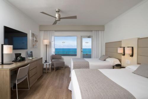 een hotelkamer met 2 bedden en uitzicht op de oceaan bij Riu Plaza Miami Beach in Miami Beach