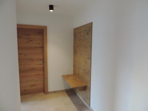 a room with two wooden doors and a bench at Ritzerhof Apartments in Stummerberg