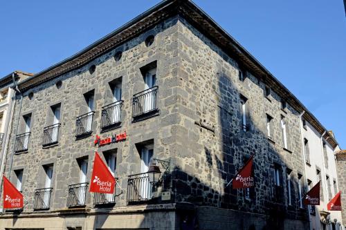a building with red flags on the side of it at Logis Hotel Yseria - Historical Center in Agde