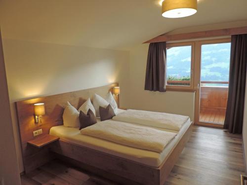 a bedroom with a bed and a large window at Ritzerhof Apartments in Stummerberg