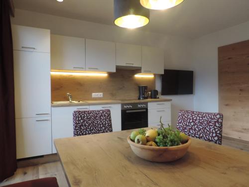 a kitchen with a bowl of fruit on a wooden table at Ritzerhof Apartments in Stummerberg