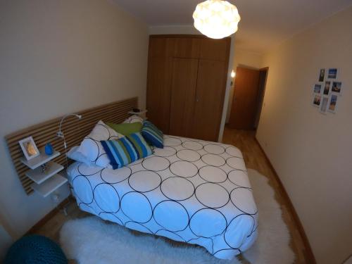 a bedroom with a large bed with blue pillows at Sea & City in Leça da Palmeira