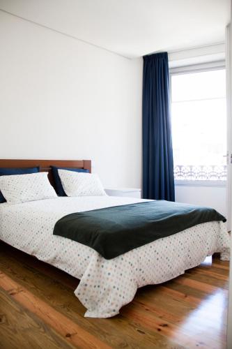 a bedroom with a bed and a window at Banho de Mar in Póvoa de Varzim