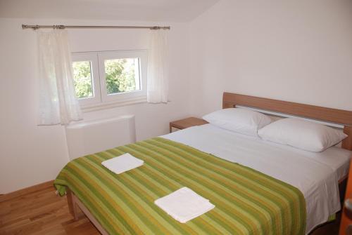a bedroom with a bed with a green and white blanket at Apartment Dakic in Herceg-Novi