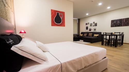 ペーゾ・ダ・レーグアにあるBugalha My Loft Douro 7のベッドルーム1室(ベッド1台付)、リビングルームが備わります。