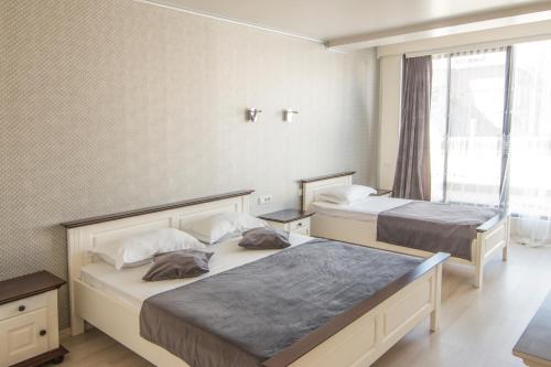 una camera d'albergo con due letti e una finestra di Hotel Merty a Constanţa