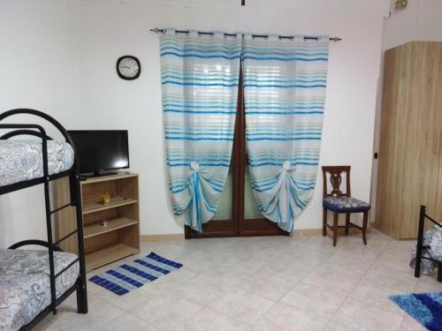 Zimmer mit einem Bett und einem Fenster mit einem Vorhang in der Unterkunft Da Rosy in Partinico