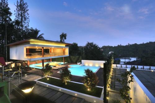 a house with a swimming pool at night at Le Villagio Resort & Domes in Sultan Bathery