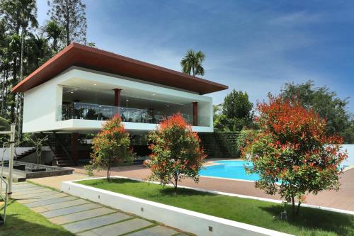 a house with a swimming pool in front of it at Le Villagio Resort & Domes in Sultan Bathery