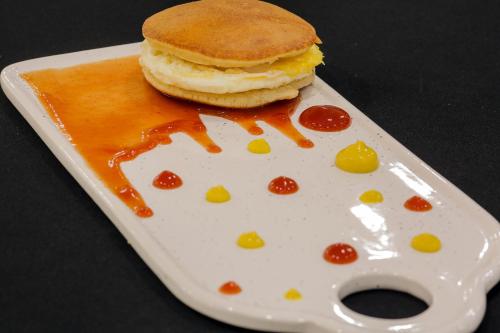 a white plate with a breakfast sandwich on it at فندق جولدن نايت Golden Night Hotel in Najran