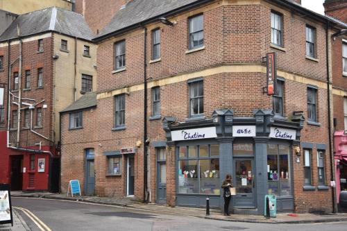 a woman standing in front of a brick building at Ali Inn Oxford in Oxford