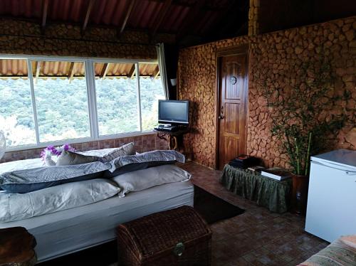 a bedroom with a bed and a television in it at Mandalas Ecolodge in Cerro Azul