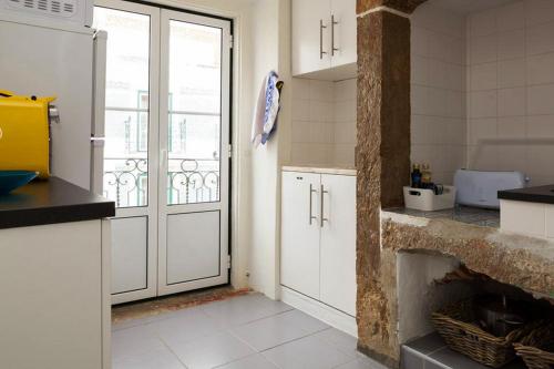 a kitchen with white cabinets and a fire place at Apartment Baixa/Chiado view Castle in Lisbon
