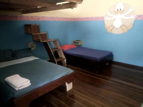 a room with two beds and a bed and a chair at Black Mamba in Paul