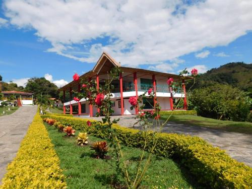 a house with flowers in front of it at Finca Hotel Guayacundo in Vergara