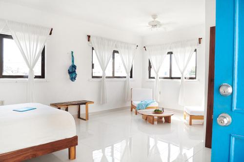 a white room with a bed and a couch at Casa el Pio in Isla Mujeres