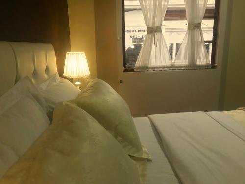 a bedroom with two white beds and a lamp at Hotel Boutique Castilla de Leòn in Cuenca