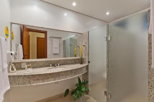 ein Badezimmer mit Waschbecken und Spiegel in der Unterkunft Aguativa Golf Resort in Cornélio Procópio