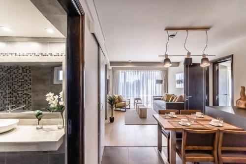 Aguila Mora Suites & Spa في سان كارلوس دي باريلوتشي: مطبخ وغرفة معيشة مع طاولة وغرفة طعام