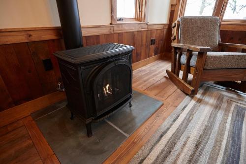 a fireplace in a room with a chair and a couch at Seesaw's Lodge in Peru