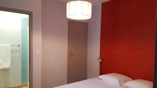 ヴィルフランシュ・ド・ルエルグにあるGITE PAGO DUPLEXの赤レンガの壁とベッドが備わるベッドルーム1室