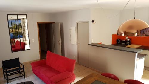 ヴィルフランシュ・ド・ルエルグにあるGITE PAGO DUPLEXのリビングルーム(赤い椅子付)、キッチン