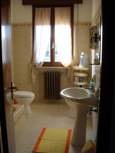 a bathroom with a sink and a toilet and a window at Casa Aurora in Fano