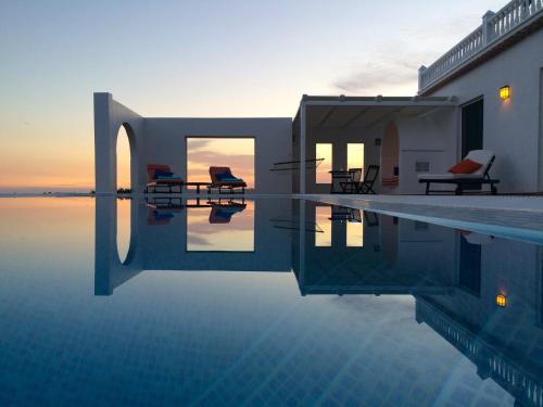 a swimming pool with two chairs and a house at Cerro del Pozo in Adra
