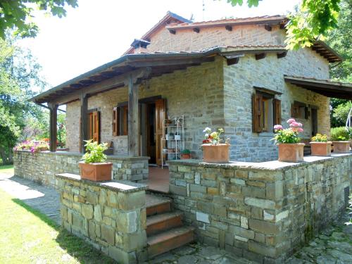 a stone house with potted plants on a stone wall at Casa Conny in Poppi