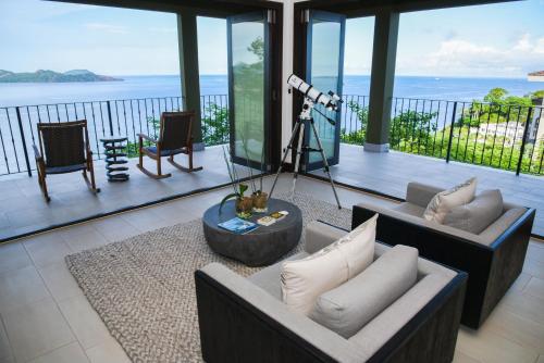 a living room with a view of the ocean at 360 Splendor Del Pacifico Residences in Playa Flamingo