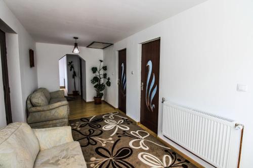 a living room with a couch and a rug at Casa Irina in Mănăstirea Humorului