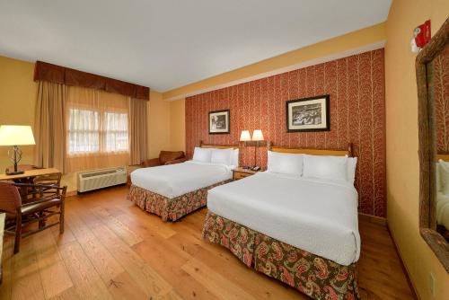 a hotel room with two beds and a desk at Bearskin Lodge on the River in Gatlinburg
