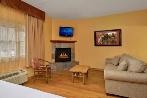 a living room with a couch and a fireplace at Bearskin Lodge on the River in Gatlinburg