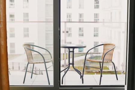グダニスクにあるMieszkanie w Riverside w centrum Starego Miastaの窓際の椅子2脚とテーブル