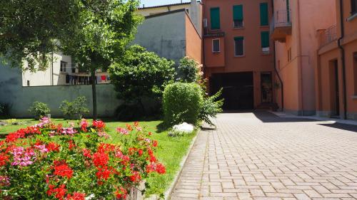 a garden with colorful flowers and a brick sidewalk at R&B Giardino 34 in Forlì