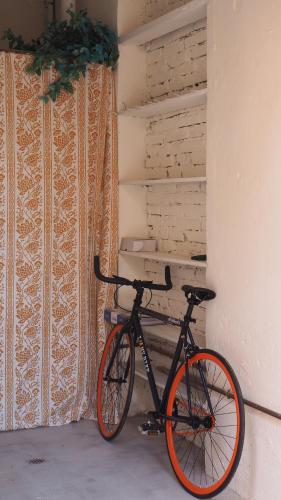 a bike parked next to a wall with curtains at R&B Giardino 34 in Forlì