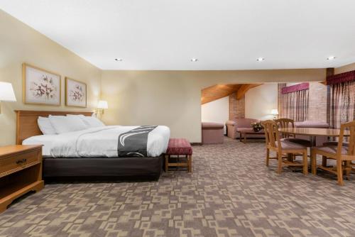 ein Hotelzimmer mit einem Bett, einem Tisch und Stühlen in der Unterkunft Quality Inn Washington Court House in Jeffersonville