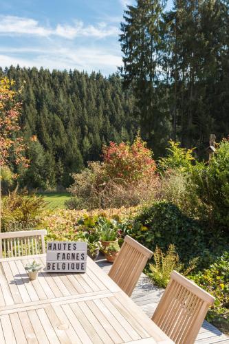 a wooden table with two chairs and a sign on it at La Belle du Bayehon in Malmedy