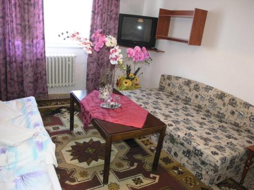 a living room with a couch and a table with flowers at Biela Labuť in Michalovce