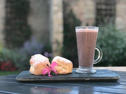 a drink and two donuts sitting on a wooden table at Poets House in Ely