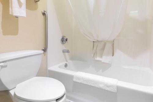 a white bathroom with a toilet and a bath tub at Quality Inn Washington Court House in Jeffersonville