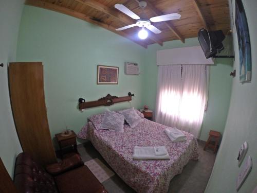 - une chambre avec un lit et un ventilateur de plafond dans l'établissement Departamentos Chacabuco Familiar, à Colón