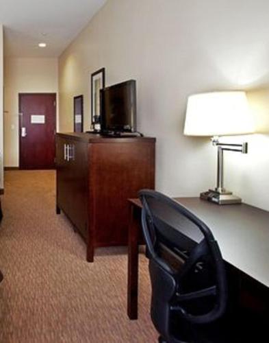 a hotel room with a chair and a desk and a lamp at Holiday Inn Express - Eunice by IHG in Eunice