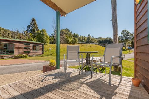 a patio with a table and chairs on a porch at Blue Lake TOP 10 Holiday Park in Rotorua