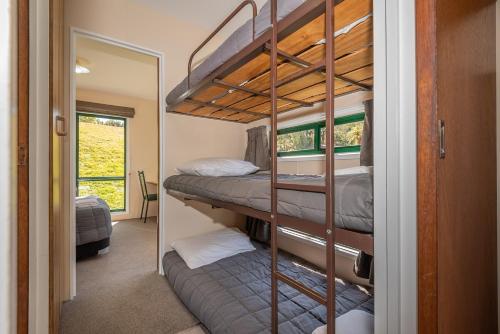 two bunk beds in a room with a mirror at Blue Lake TOP 10 Holiday Park in Rotorua
