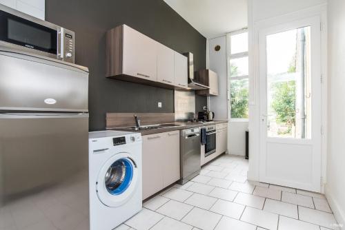 a kitchen with a washing machine and a dishwasher at Appartements Scaliger Wifi Proche Gare in Agen