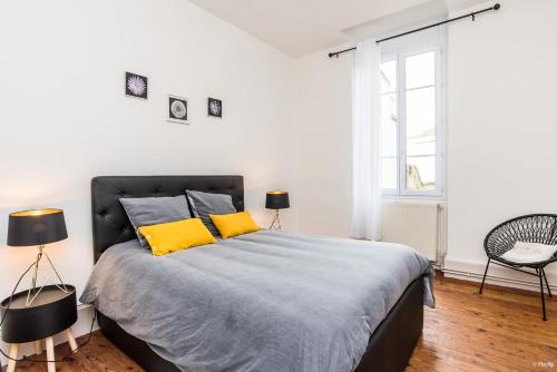 a bedroom with a large bed with yellow pillows at Appartements Scaliger Wifi Proche Gare in Agen