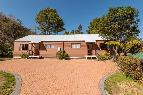 a house with a brick driveway in front of it at Blue Lake TOP 10 Holiday Park in Rotorua